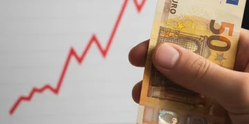 Hand holding a euro banknote, symbolizing savings protection against inflation in Spain 2026.